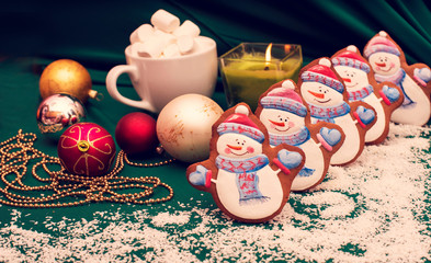 Congratulatory background with christmas-world cookies in the form of snowmen as a symbol of the new year 2019 with New Year's toys and a candle (greeting card, greetings - concept)