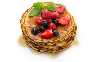 Delicious pancakes with berries and maple syrup top view, white background