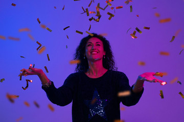 Portrait of beautiful woman playing with confetti . Celebration, Birthday, Christmas, New Year.