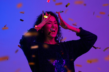 Portrait of beautiful woman playing with confetti . Celebration, Birthday, Christmas, New Year.