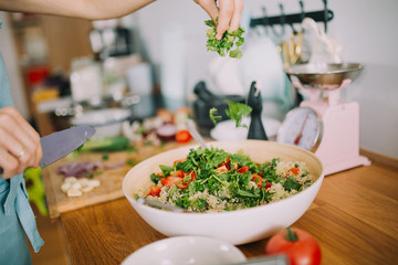 Woman preparation couscous fresh and healthy salad in modern kitchen.