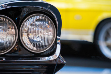 Fototapeta premium Close up view of a fragment a round headlights of vintage auto. Exhibition of retro cars.
