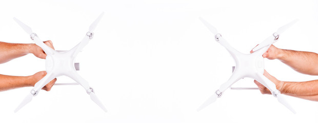 Four hands hold flying drones. Flying drones on black background. Theme selling and buying drone.