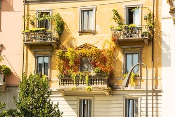 Balcony with flowers and greens in an old house in Milan Italy. Architecture of Milan.