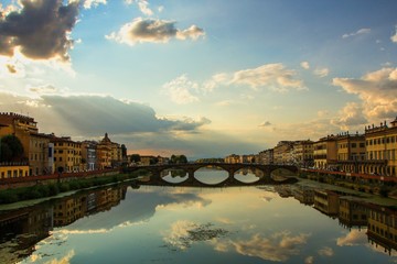 The Ponte alla Carraia Bridge is a five-arched bridge spanning the River Arno and linking the district of Oltrarno. Beautiful evening landscape in the rays of the setting sun. Florence, Italy. - obrazy, fototapety, plakaty