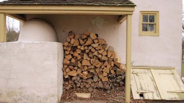 Stack of firewood outside of colonial builiding