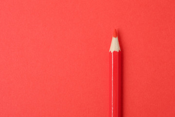 Red pencil on red paper background. Close up.