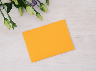 Envelope and roses flowers on white wooden table. Flat lay. Top view.