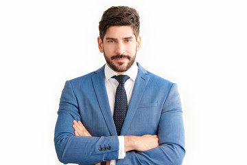 Confident young businessman wearing suit while standing at isolated background