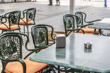 Typical tables and chairs outside a bar in Madrid, with napkins and ashtray