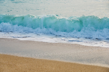                      Waves with foam hitting sand on the beach texture.          