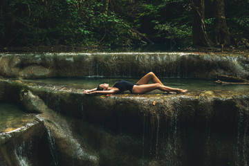 Sexy woman in the jungle with beautiful waterfall