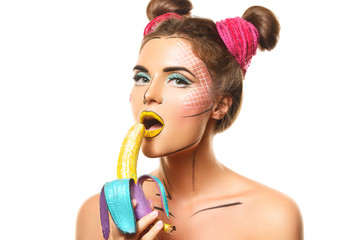 Beautiful model with creative pop art makeup holding banana