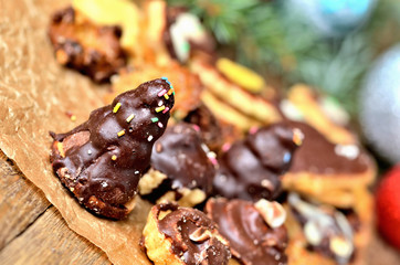 Close-up of christmas sweets with different types of candy on baking paper and Christmas decorations in background