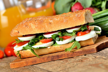 Sandwich with egg, arugula salad, tomatoes and radish