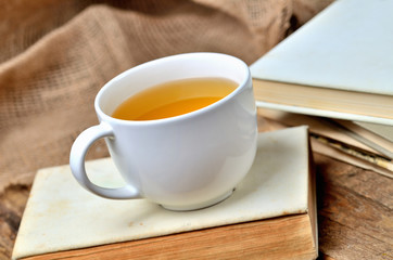 Mug of black tea on an old, vintage shabby book