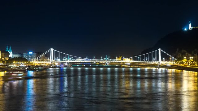 Night Time Lapse scene of the Elizabeth bridge in Budapest with boat traffic on Danube river filmed from the Chain Bridge. 