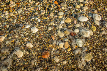 wet sea shore colorful waterfront stones background texture shot from above