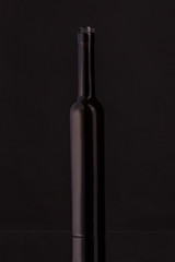Wine bottle on a black background. Soft beautiful highlights on the bottle.