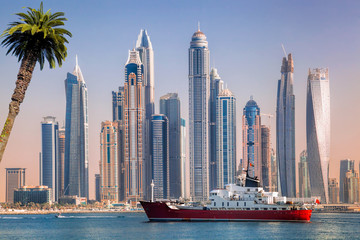 Panorama of Dubai with ship against skyscrapers in UAE