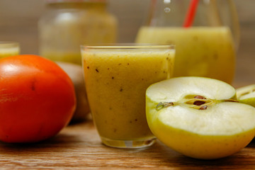 Freshly blended fruit smoothie with fresh fruits on wooden table with raw fruits