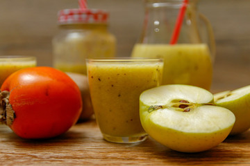 Freshly blended fruit smoothie with fresh fruits on wooden table with raw fruits