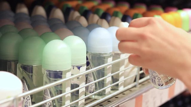Female hands choose deodorant in the store
