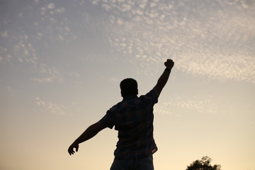 Fototapeta na wymiar silhouette of a man with his arms raised