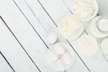 Different dairy products on the white wooden boards