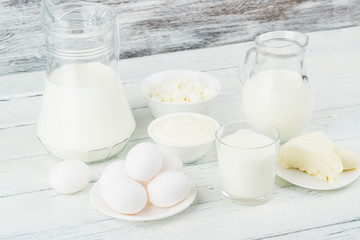 Different dairy products on the white wooden boards