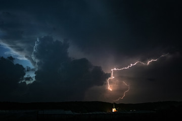 Thunderclouds and lightning over a church and village in Transylvania, Romania.