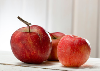several red apple on old wooden background, close-up