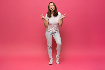 Happy beautiful girl standing in full length, isolated on pink background. © opolja