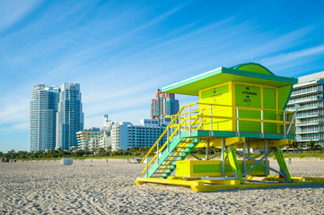 Fototapeta na wymiar Brightly colored lifeguard tower standing empty in sunrise light on South Beach, Miami, Florida, USA