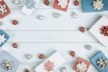 Christmas composition with copy space. In a circle of blue background are red and silver Christmas balls, gift boxes with bows. Festive layout .