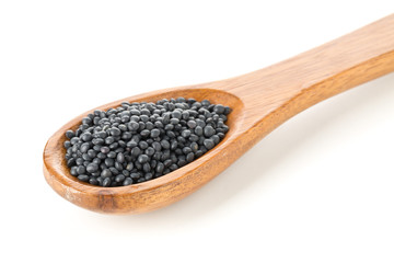 Heap of black organic beluga lentils in wooden spoon on white