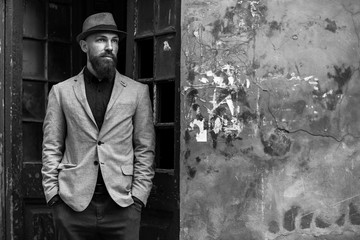 stylish man with a beard in a hat on the street