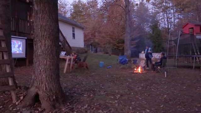 Family Bonfire And Movie Night In Backyard Of House