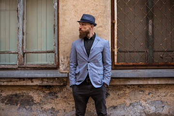 stylish man with a beard in a hat on the street