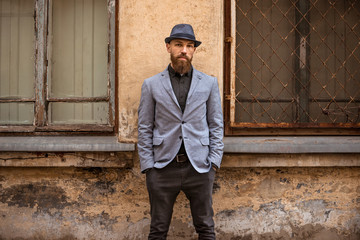 stylish man with a beard in a hat on the street