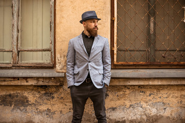 stylish man with a beard in a hat on the street