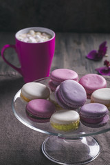 Macaroons on glass plate and mug, toned