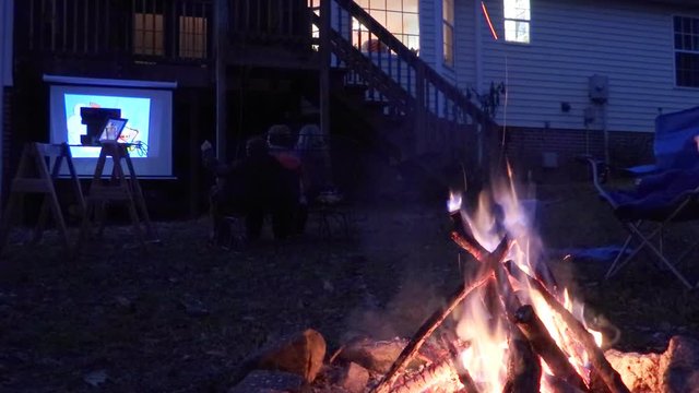 Family Bonfire And Movie Night In Backyard Of House
