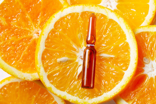 Vitamin C, natural treatment concentrate over orange slices concept
