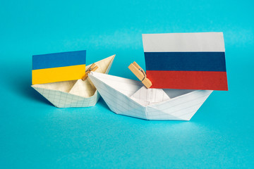 paper ships with flags of Ukraine and Russia, symbol of conflict at sea 