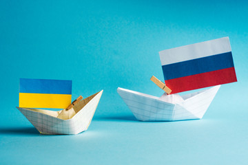 paper ships with flags of Ukraine and Russia, symbol of conflict at sea 