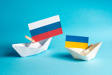 paper ships with flags of Ukraine and Russia, symbol of conflict at sea 