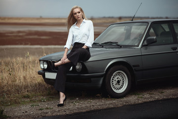 Beautiful blond lady in black striped high waisted pants, white blouse and high heeled shoes...