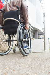 Fototapeta premium Man in a wheelchair use a wheelchair ramp.