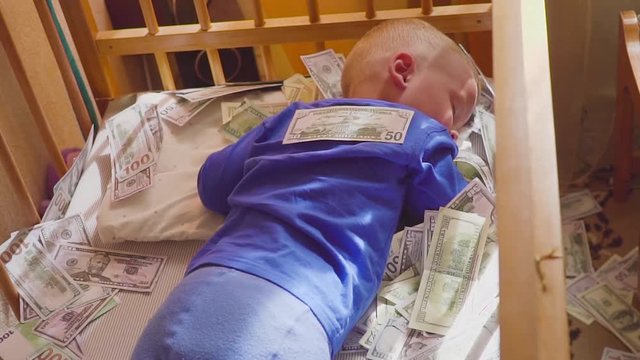 sleeping baby and falling money. Concept unexpected wealth. A big win.